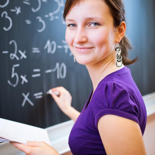 Teacher in front of classroom smiling