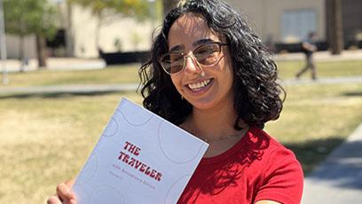 GCC Student holding the 60th Anniversary edition of "The Traveler"