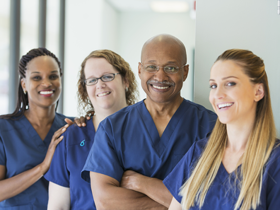 Smiling nursing students in blue scrubs